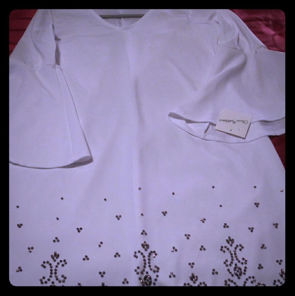 A white dress with gold color bead design